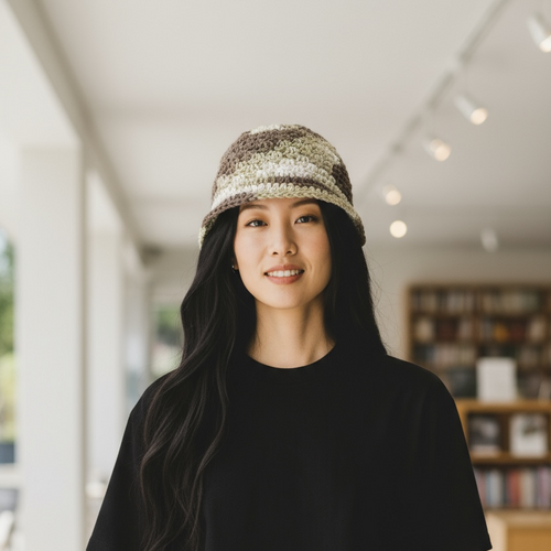 Woman wearing a black outfit and patterned crocheted hat indoors